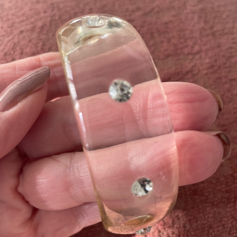 Bangle clear lucite, diamond like stones every 1 inch. 1" wide. Smoke free.